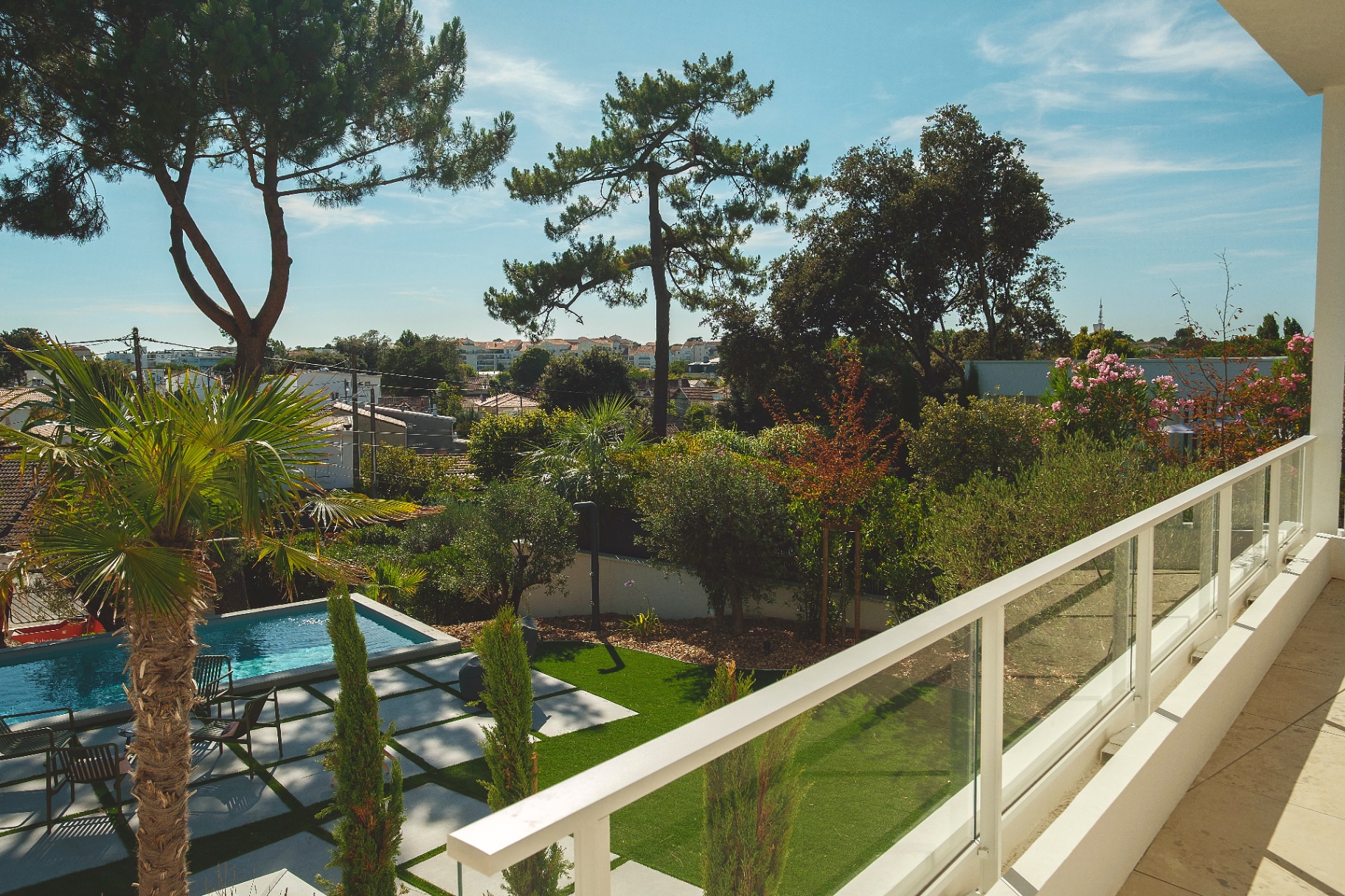 Vue depuis le balcon sur la piscine et le jardin